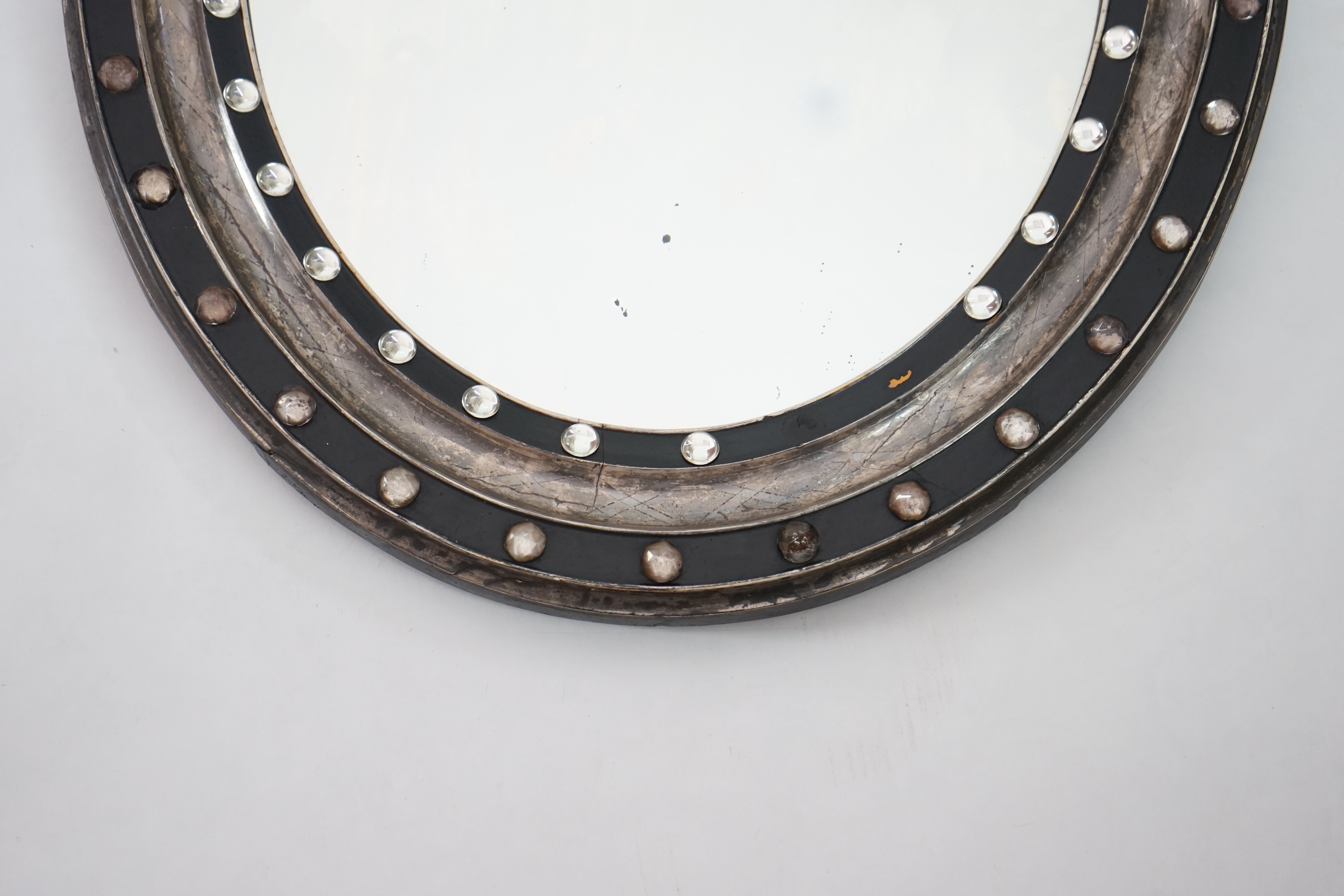 A 19th century Irish ebonised and silvered frame oval wall mirror